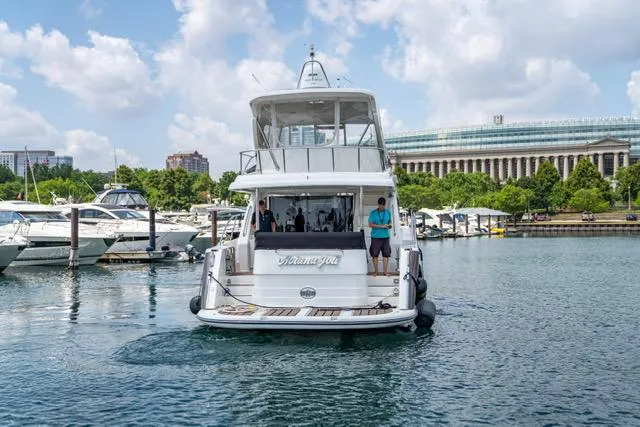  Yacht Photos Pics Neptunus 62 Flybridge yacht, 2005 model, docked in a marina with cityscape background.