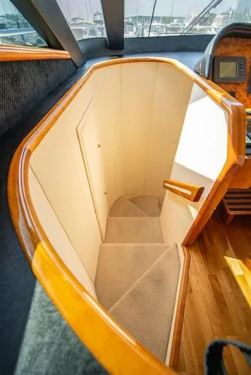  Yacht Photos Pics Staircase in 2005 Neptunus 62 Flybridge yacht with wooden accents and carpeted steps.