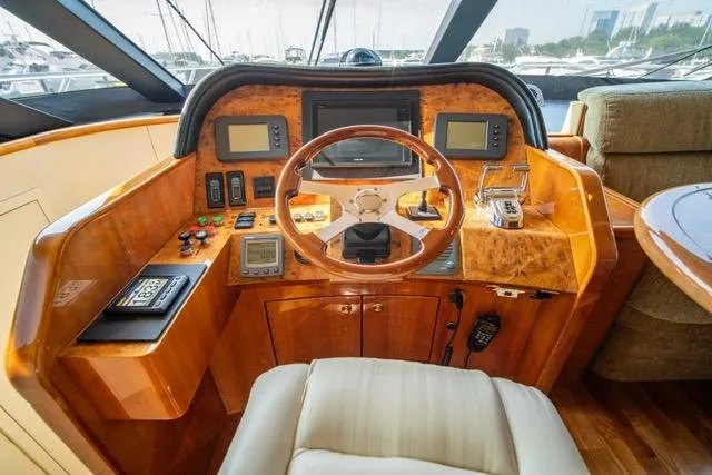  Yacht Photos Pics Luxurious 2005 Neptunus 62 Flybridge yacht helm with wood finish and modern controls.