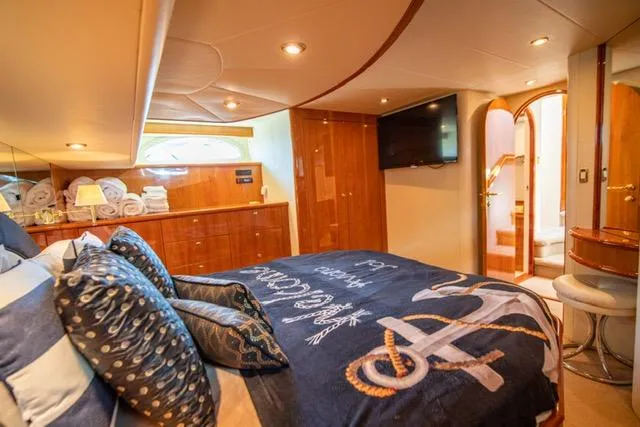  Yacht Photos Pics Luxurious 2005 Neptunus 62 Flybridge yacht bedroom with nautical decor and modern amenities.