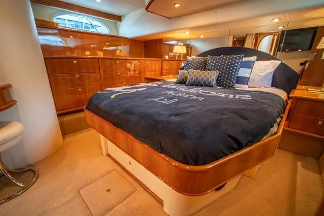  Yacht Photos Pics Luxurious bedroom interior of 2005 Neptunus 62 Flybridge yacht with elegant wood finishes.
