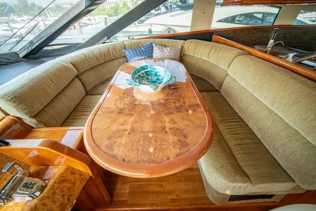  Yacht Photos Pics Luxurious 2005 Neptunus 62 Flybridge yacht interior with elegant wood table and plush seating.