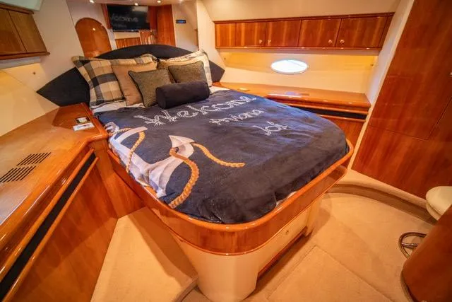  Yacht Photos Pics Luxurious bedroom interior of 2005 Neptunus 62 Flybridge yacht with elegant wood finish.
