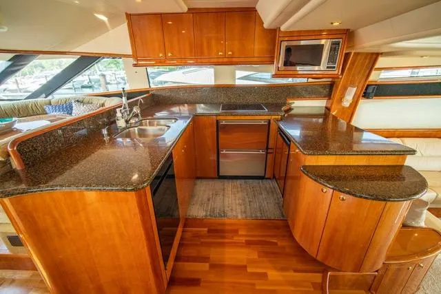  Yacht Photos Pics Luxurious kitchen in 2005 Neptunus 62 Flybridge yacht with wood cabinetry and granite countertops.