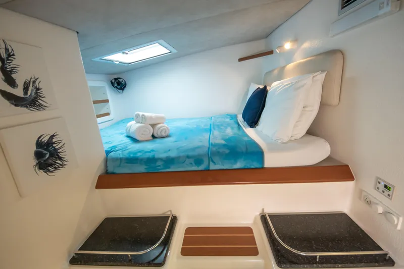 Osprey Yacht Photos Pics Cozy cabin interior of 2011 Voyage Yachts 520 with skylight and blue bedding.