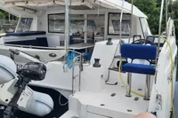 Nautitech 40 Open catamaran, 2014 model, docked with inflatable boat and lush greenery background.