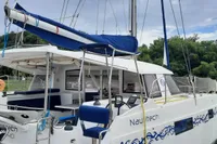 Nautitech 40 Open 2014 catamaran docked, featuring blue accents and lush greenery in the background.