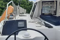 Nautitech 40 Open catamaran deck with steering wheel, ropes, and lush greenery in the background.