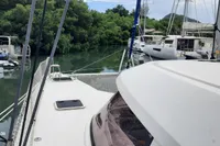 Nautitech 40 Open catamaran docked near lush greenery, showcasing sleek design and spacious deck.