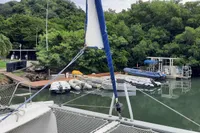 Nautitech 40 Open catamaran docked near lush greenery and calm waters, 2014 model.