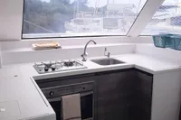 Modern kitchen interior of 2014 Nautitech 40 Open yacht with stove, sink, and window view.
