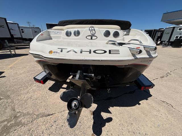 2014 Tracker Tahoe Q5 boat rear view with propeller, parked on concrete under clear sky.