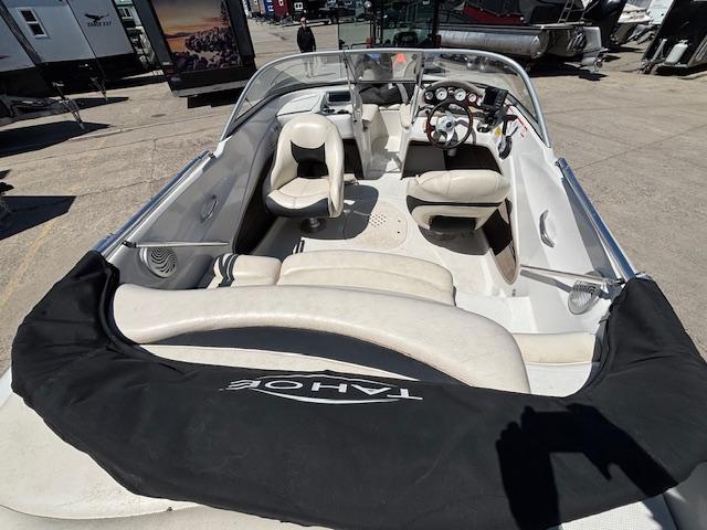 2014 Tracker Tahoe Q5 boat interior with steering wheel and seating, parked outdoors.