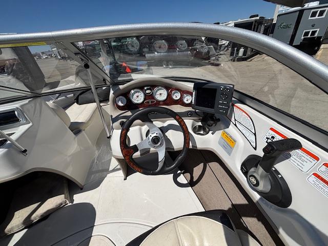 2014 Tracker Tahoe Q5 boat dashboard with steering wheel and gauges under clear blue sky.