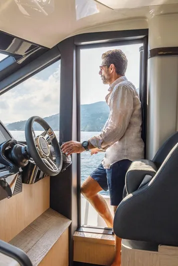 Absolute 47 Fly Yacht Photos Pics Man enjoying view on 2025 Absolute 47 Fly yacht, near steering wheel.