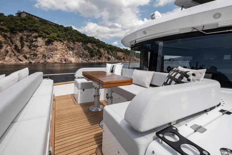  Yacht Photos Pics Luxurious Sirena 60 yacht deck with elegant seating, wooden table, and scenic coastal view, 2026 model.