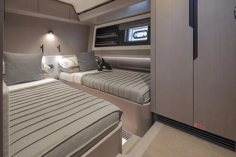  Yacht Photos Pics Modern twin cabin interior on 2026 Sirena 60 yacht, featuring sleek design and cozy bedding.