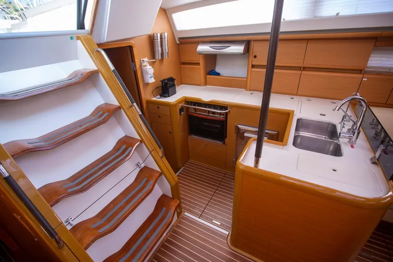 Amelie Yacht Photos Pics Interior of 2011 Jeanneau 57 yacht featuring modern kitchen and wooden stairs.