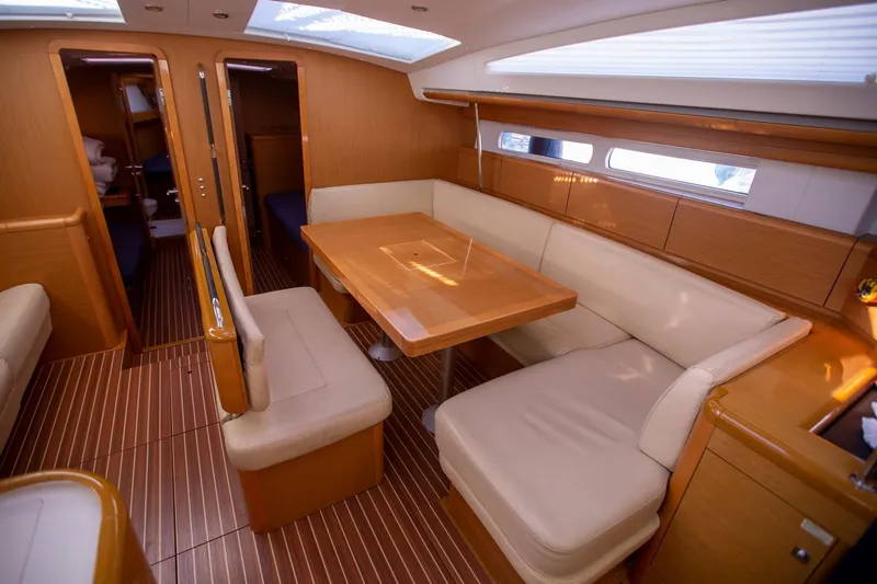 Amelie Yacht Photos Pics Luxurious interior of 2011 Jeanneau 57 yacht with elegant dining area and wooden finishes.