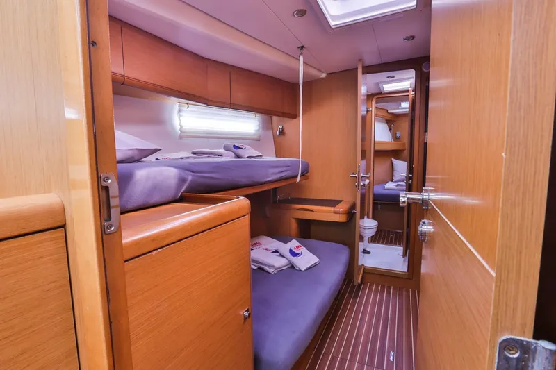 Amelie Yacht Photos Pics Luxurious 2011 Jeanneau 57 yacht cabin with wooden interior and cozy bunk beds.