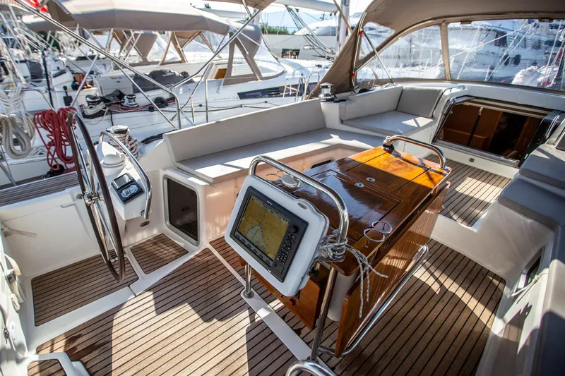 Amelie Yacht Photos Pics Luxurious 2011 Jeanneau 57 yacht cockpit with wooden deck and navigation equipment.