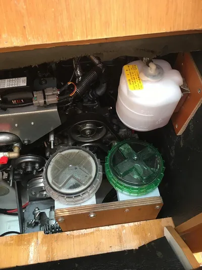 Amelie Yacht Photos Pics Engine compartment of a 2011 Jeanneau 57 sailboat, showcasing mechanical components and fluid containers.