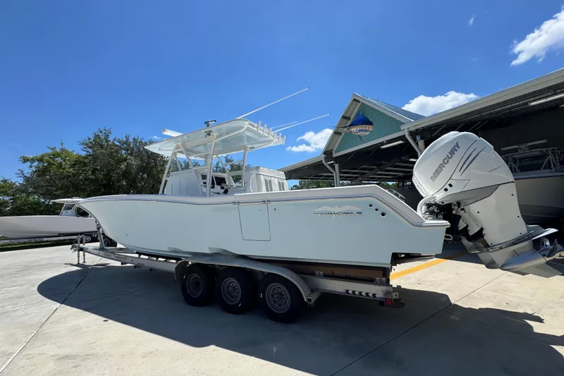  Yacht Photos Pics 2021 Invincible 36 Open Fisherman boat on trailer, parked outdoors under clear blue sky.