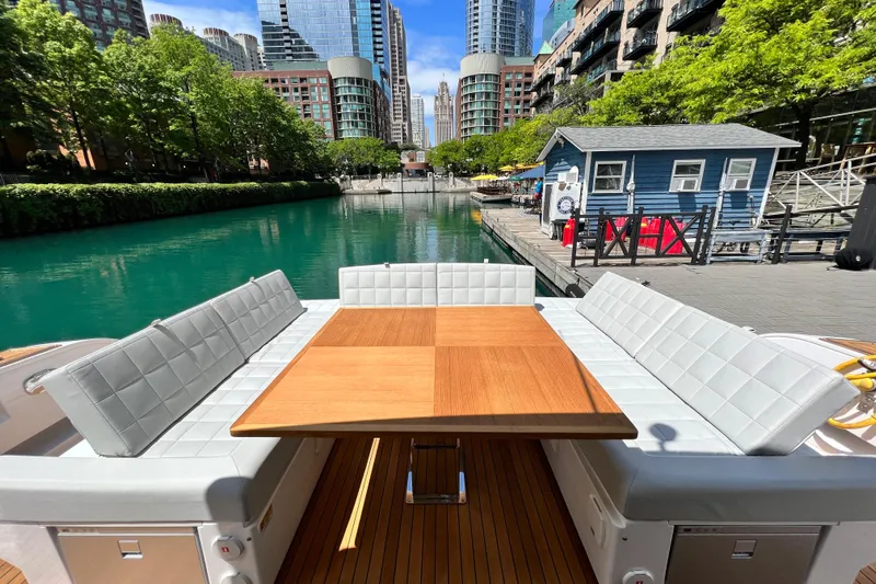 Yacht Photos Pics 2026 Pardo Yachts GT52 with elegant seating and table, docked in a scenic urban canal.