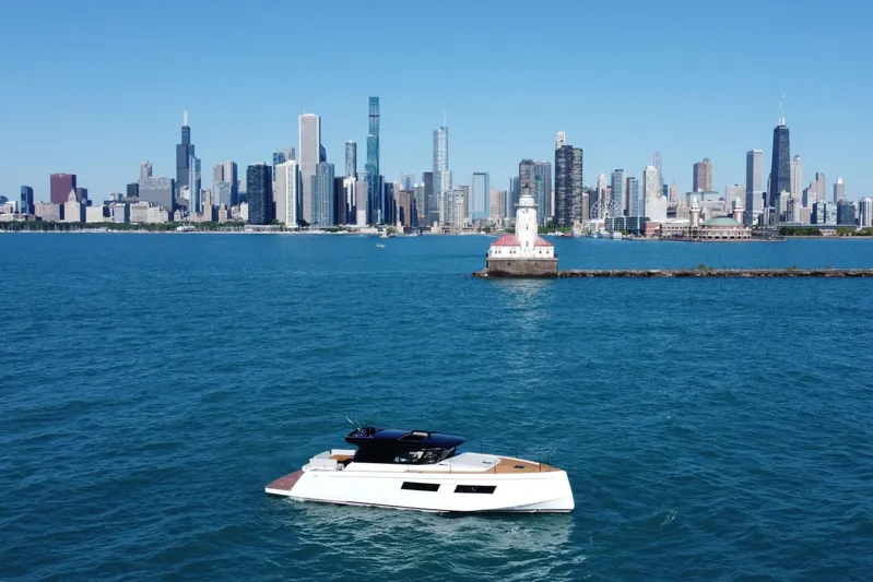  Yacht Photos Pics 2026 Pardo Yachts GT52 cruising near a city skyline and lighthouse.