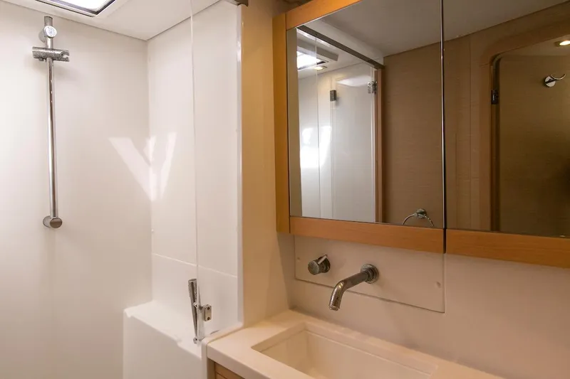King Lewis Yacht Photos Pics Modern bathroom in a 2016 Lagoon 450 yacht, featuring a sleek shower and mirrored cabinet.