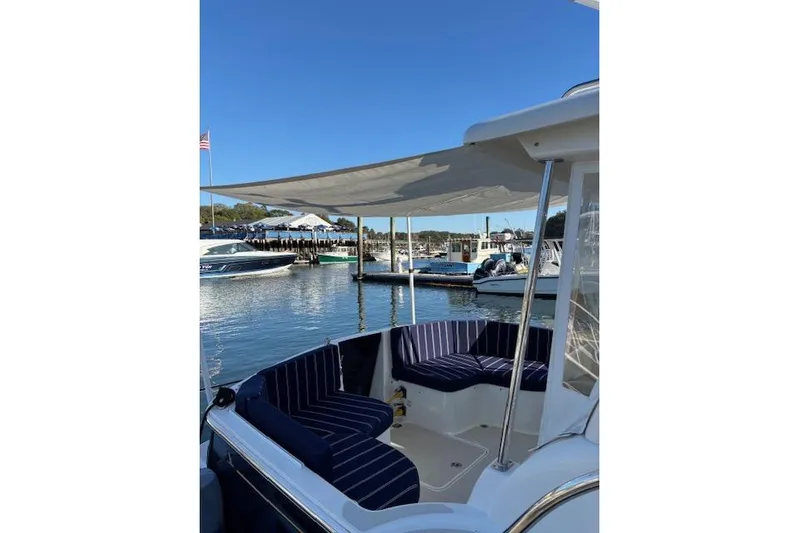 Hannah E Yacht Photos Pics 2018 Back Cove 30 boat with striped seating, docked in a sunny marina.