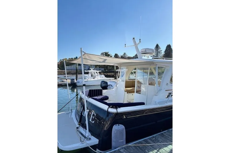 Hannah E Yacht Photos Pics 2018 Back Cove 30 boat docked, featuring a canopy and sleek design.