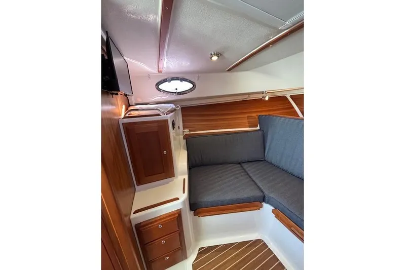 Hannah E Yacht Photos Pics 2018 Back Cove 30 interior with wooden cabinets and gray cushioned seating.