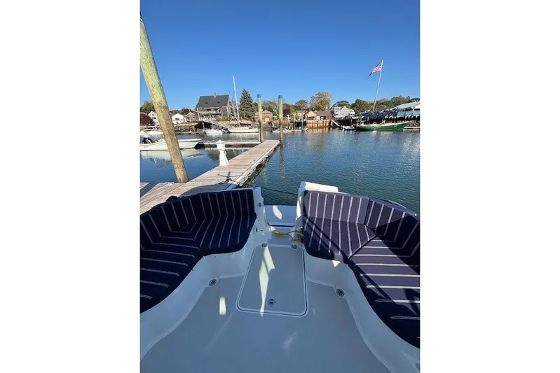 Hannah E Yacht Photos Pics 2018 Back Cove 30 boat docked, featuring striped seating and a scenic marina view.
