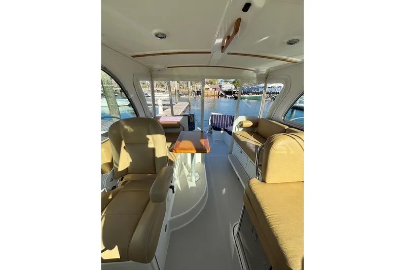 Hannah E Yacht Photos Pics Interior of a 2018 Back Cove 30 boat with beige seating and a wooden table.
