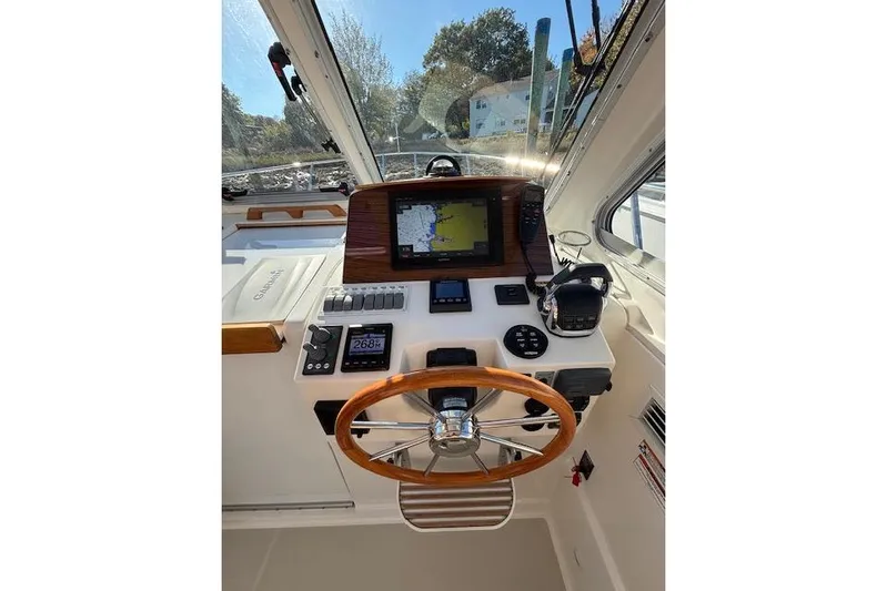 Hannah E Yacht Photos Pics 2018 Back Cove 30 boat helm with navigation equipment and wooden steering wheel.