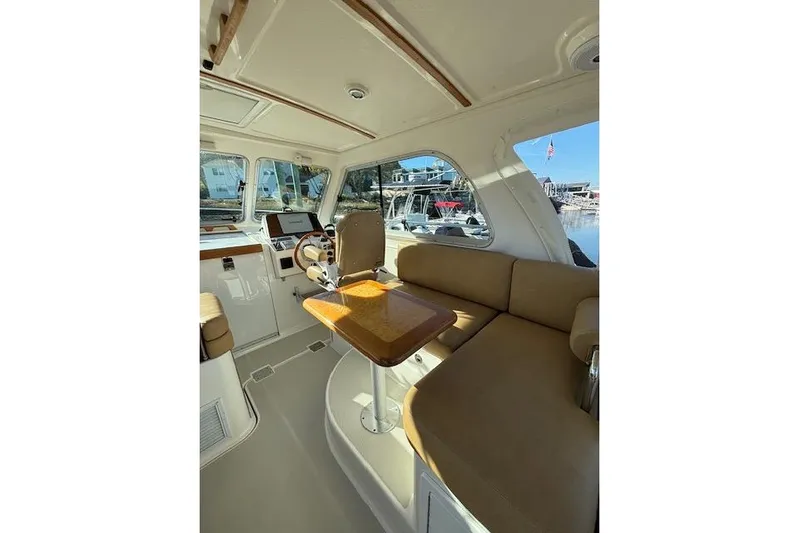 Hannah E Yacht Photos Pics Interior of a 2018 Back Cove 30 boat with beige seating and wooden table.