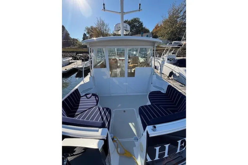 Hannah E Yacht Photos Pics 2018 Back Cove 30 boat with striped seating, docked under sunny skies.