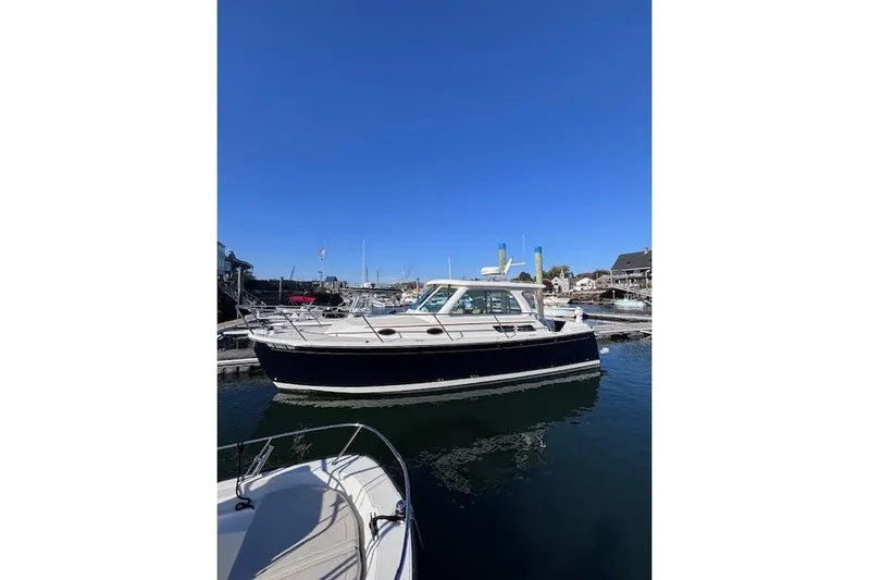 Hannah E Yacht Photos Pics 2018 Back Cove 30 boat docked in a marina under clear blue skies.