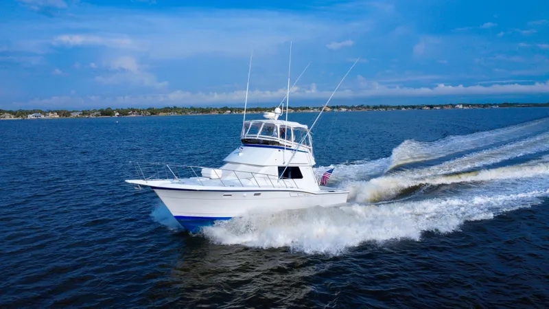 Reel Amnesia Yacht Photos Pics 1984 Hatteras 36 Convertible yacht cruising on open water under a clear blue sky.