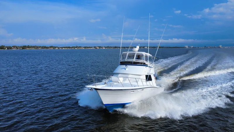 Reel Amnesia Yacht Photos Pics 1984 Hatteras 36 Convertible cruising on open water under clear blue skies.