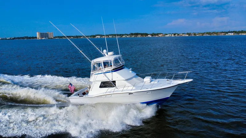Reel Amnesia Yacht Photos Pics 1984 Hatteras 36 Convertible yacht cruising on open water under clear blue skies.