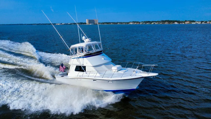 Reel Amnesia Yacht Photos Pics 1984 Hatteras 36 Convertible yacht cruising on open water, creating a dynamic wake.
