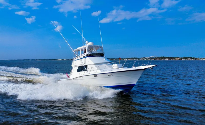 Reel Amnesia Yacht Photos Pics 1984 Hatteras 36 Convertible yacht cruising on open water under blue sky.