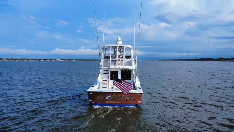 Reel Amnesia Yacht Photos Pics 1984 Hatteras 36 Convertible boat on open water with American flag.