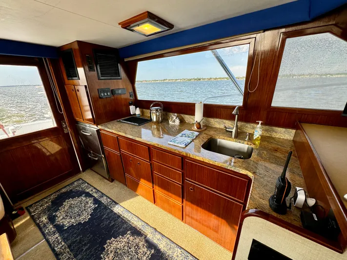 Reel Amnesia Yacht Photos Pics Interior of 1984 Hatteras 36 Convertible yacht with wooden cabinetry and ocean view.