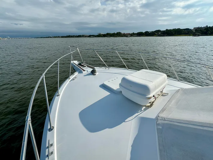 Reel Amnesia Yacht Photos Pics 1984 Hatteras 36 Convertible yacht on calm waters under a cloudy sky.