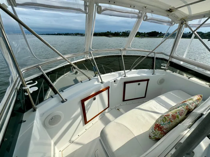 Reel Amnesia Yacht Photos Pics 1984 Hatteras 36 Convertible boat interior with white seating and floral cushion, overlooking calm waters.
