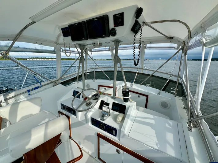 Reel Amnesia Yacht Photos Pics 1984 Hatteras 36 Convertible yacht helm with modern navigation equipment on calm waters.