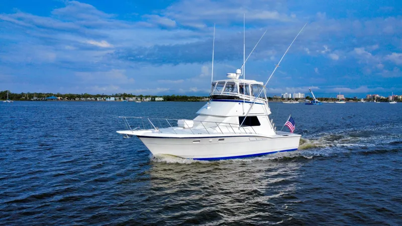 Reel Amnesia Yacht Photos Pics 1984 Hatteras 36 Convertible yacht cruising on open water under a blue sky.